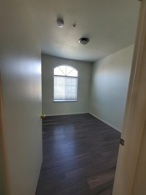 A room with a window and wooden floors.