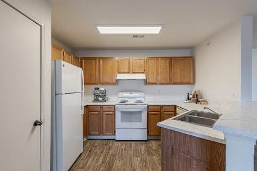 A kitchen with wooden cabinets and a white fridge.