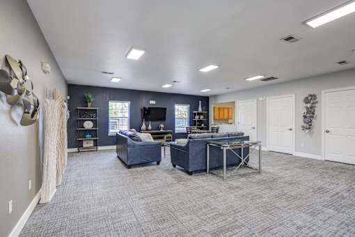 A spacious room with a blue couch and a desk.