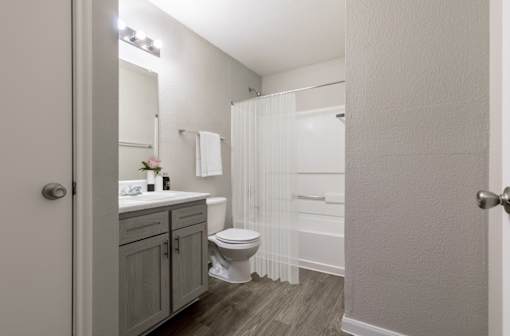 A bathroom with a toilet, sink, and shower.