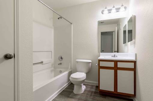 A white bathroom with a toilet, sink, and bathtub.