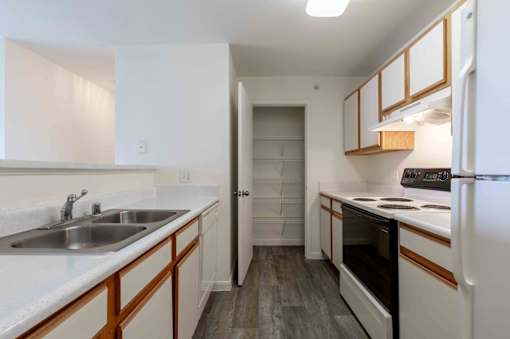 A kitchen with white cabinets and a white refrigerator.