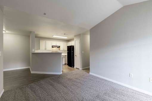 A spacious room with a kitchenette and a refrigerator.