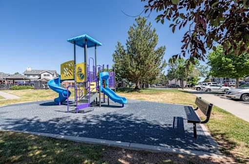 A playground with a purple slide and a yellow slide.