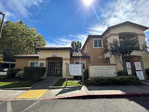 A sunny day at Creekside Village Apartments with a clear blue sky.