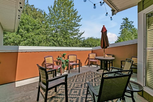 a patio with chairs and tables and an umbrella