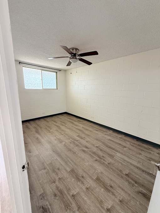 A room with a ceiling fan and a window.