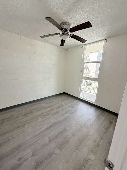 A room with a ceiling fan and a window.