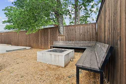 A wooden bench sits in front of a wooden fence.