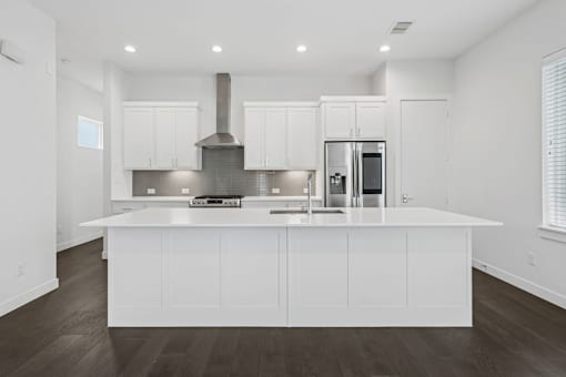 A modern kitchen with white cabinets and a large island.