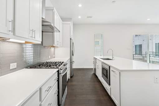A modern kitchen with white cabinets and stainless steel appliances.