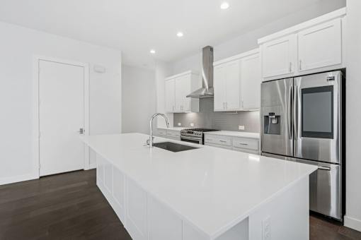 A modern kitchen with white cabinets and stainless steel appliances.