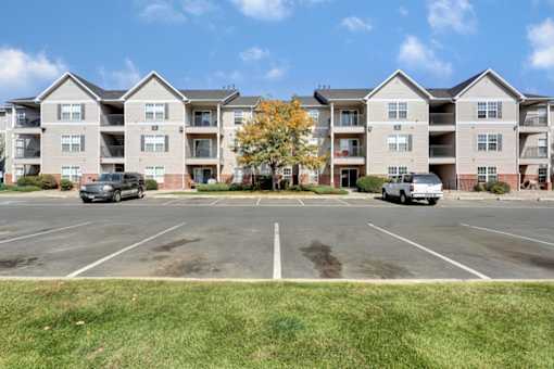 A parking lot in front of apartment buildings.