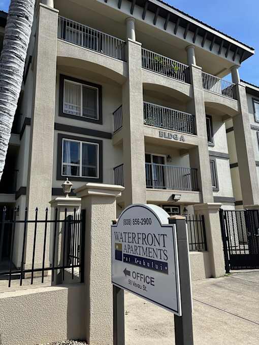 A sign for the Waterfront Apartments is in front of a building.