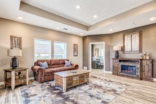 A living room with a brown couch and a wooden coffee table.