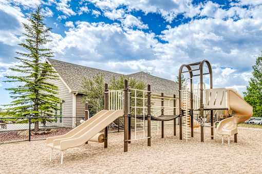 A playground with a slide, swings, and a climbing frame.