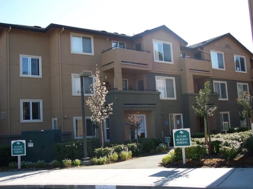 an apartment building with a sidewalk in front of it