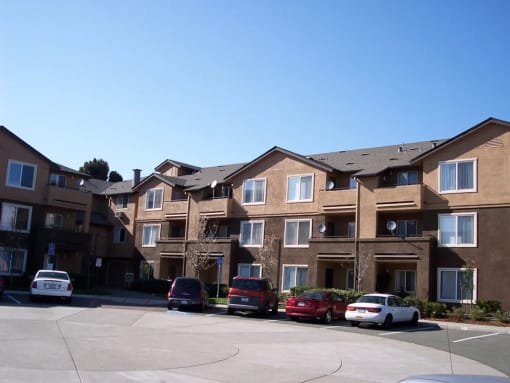 an apartment building with cars parked in front of it