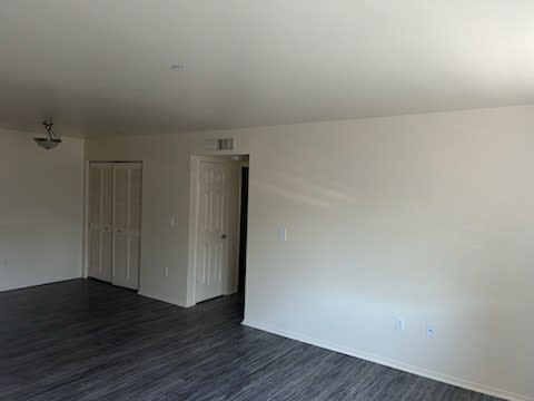 A room with two doors and a wooden floor.