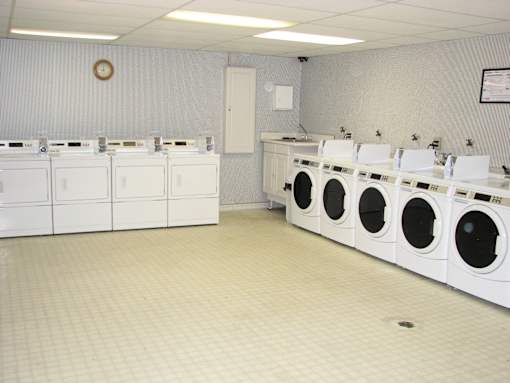 A row of white washing machines in a laundromat.
