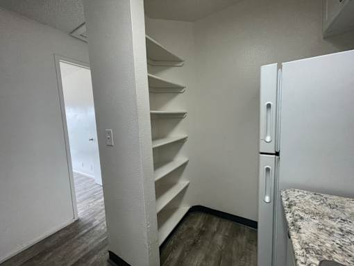 Cluster Park kitchen pantry and white fridge.