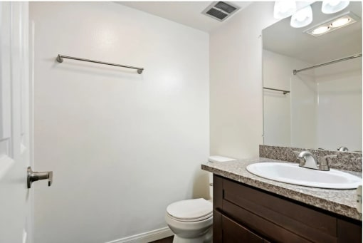 a bathroom with a sink toilet and a mirror
