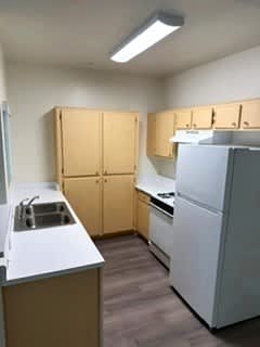 Sorrento Villas kitchen with a sink, refrigerator, and cabinets.