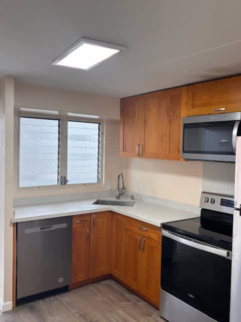 Napili Towers kitchen with wooden cabinets and stainless steel appliances.