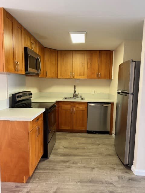 Napili Towers kitchen with wooden cabinets and a refrigerator.