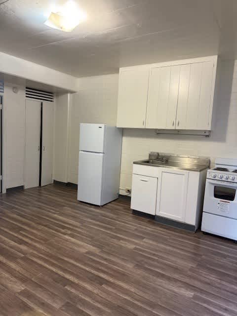 Pacific Oasis kitchen with white appliances and wooden floors.