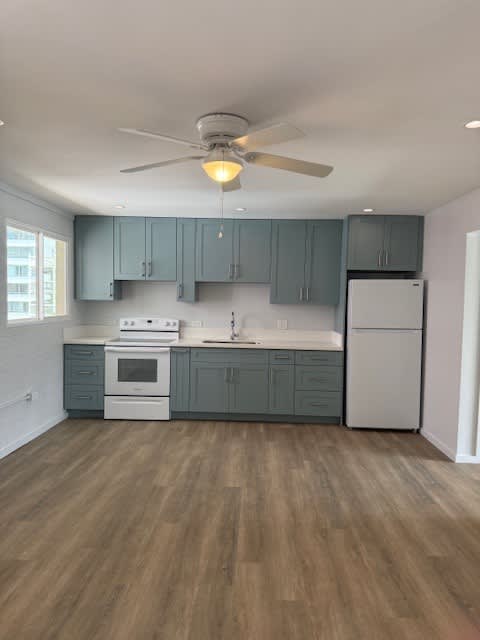 Pacific Oasis kitchen with a white refrigerator and wooden floors.