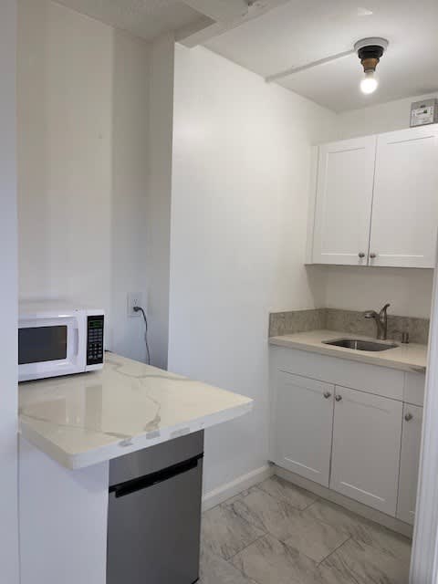 A kitchen with white cabinets and a countertop.