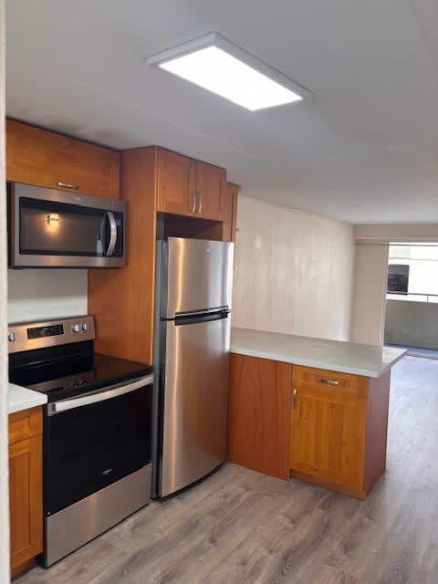 Napili Towers kitchen with a stainless steel refrigerator, microwave, and oven.