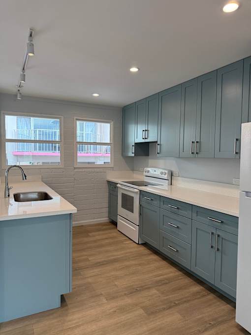Pacific Oasis kitchen with a white counter top and blue cabinets.