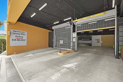 A parking garage for apartments with a sign that says Apartments Leasing Office Parking.