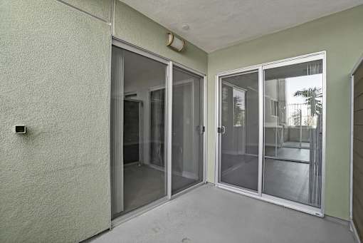 A room with a sliding glass door and a wall-mounted light fixture.