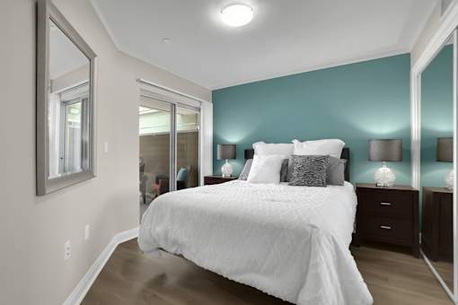 A bedroom with a large bed and a mirror on the wall.