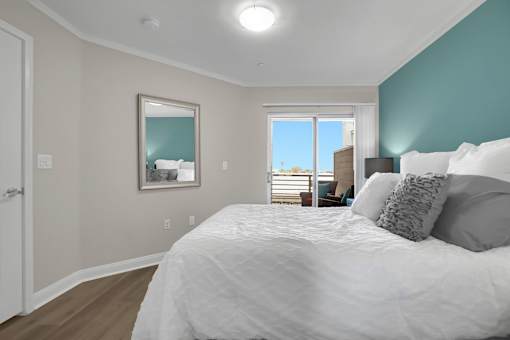 A bedroom with a large bed and a view of the outside through the window.