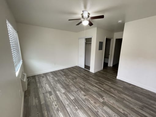 an empty living room with a ceiling fan