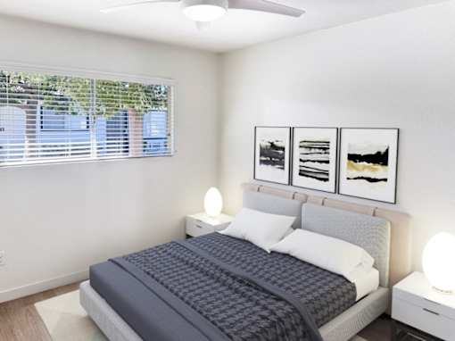 A bedroom with a bed, nightstands, and pictures on the wall.