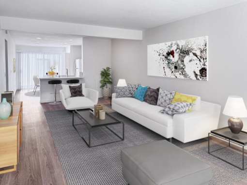 A modern living room with a white couch, a coffee table, and a large abstract painting on the wall.