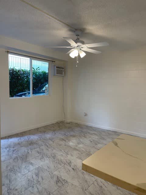 A room with a ceiling fan and a window.