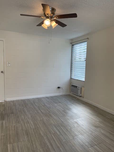 A room with a ceiling fan and a window with blinds.