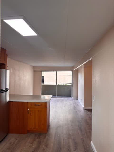 Napili Towers kitchen with wooden cabinets and a refrigerator.