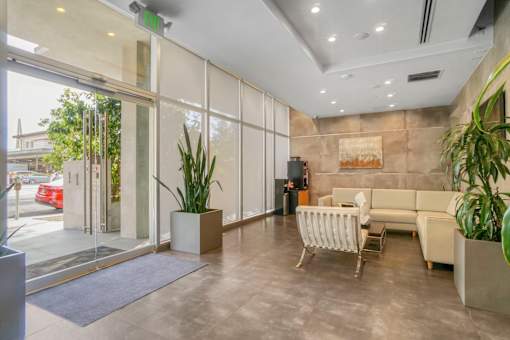 A modern living room with a glass door leading to a balcony.