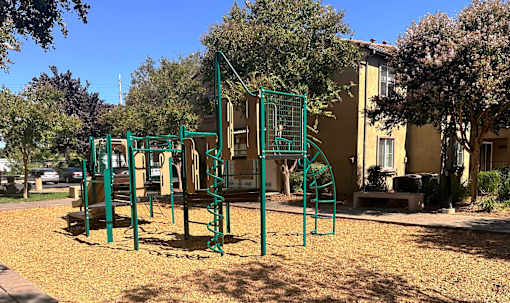 a playground in a park in front of a building