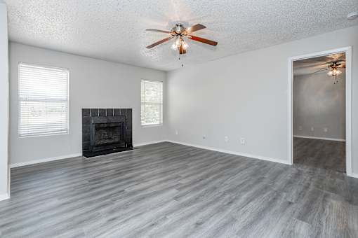 A room with a fireplace and a ceiling fan.