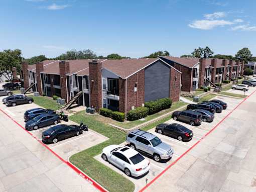 A parking lot with cars and a building in the background.