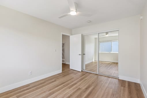 A room with a sliding glass door and a ceiling fan.
