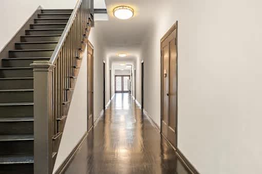 A long hallway with a staircase on the left side.